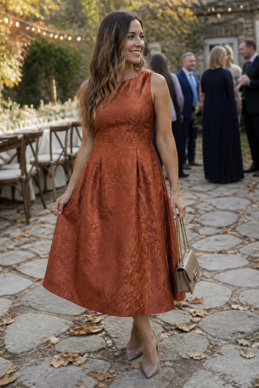 A woman wearing a copper A-line jacquard dress at an outdoor fall wedding.