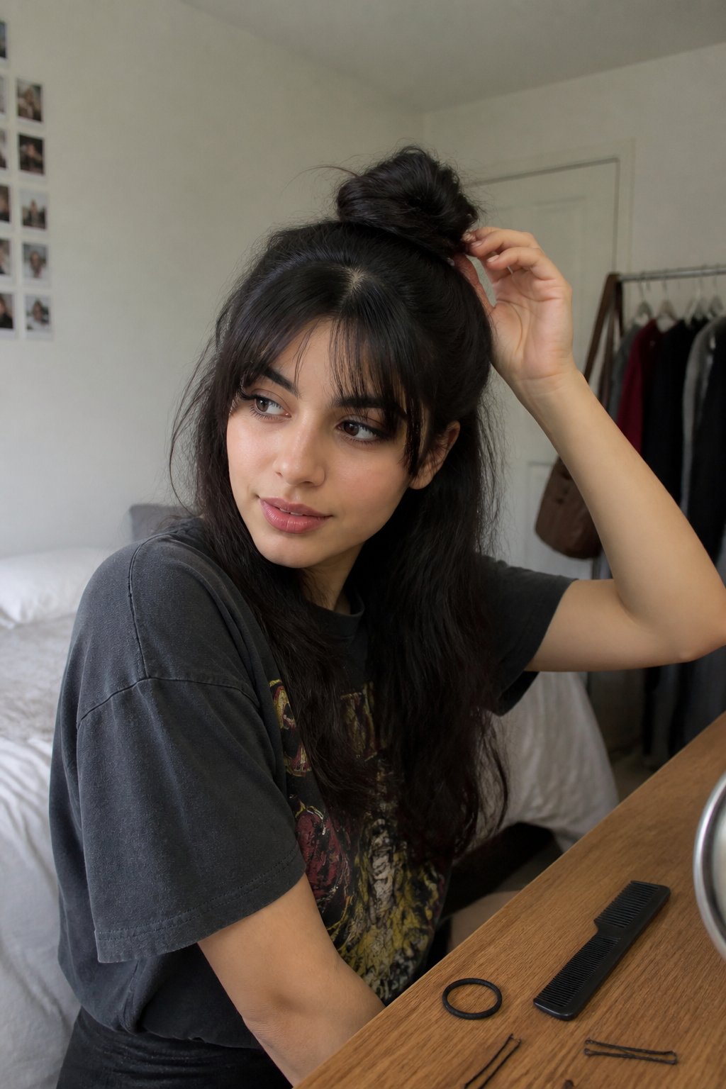 Person wearing a half-up top knot with curtain bangs while getting ready in a room.